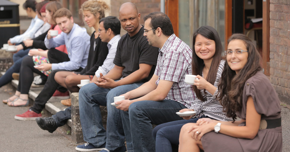 Postgraduate students sat in a line (at the 2018 PGR GW4 Collaboration and Connection Summer School).