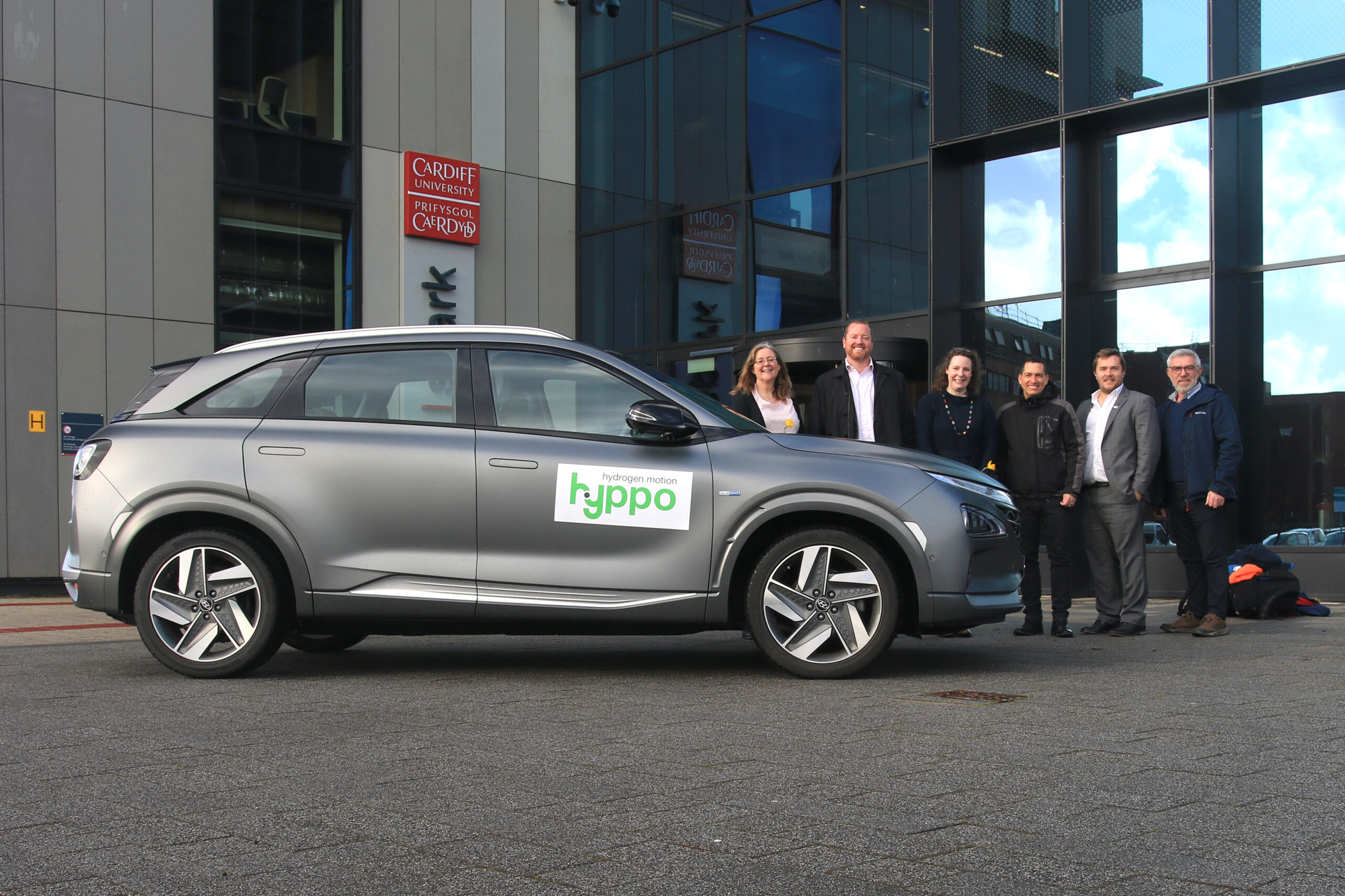 Group of people stood behind a hydrogen car