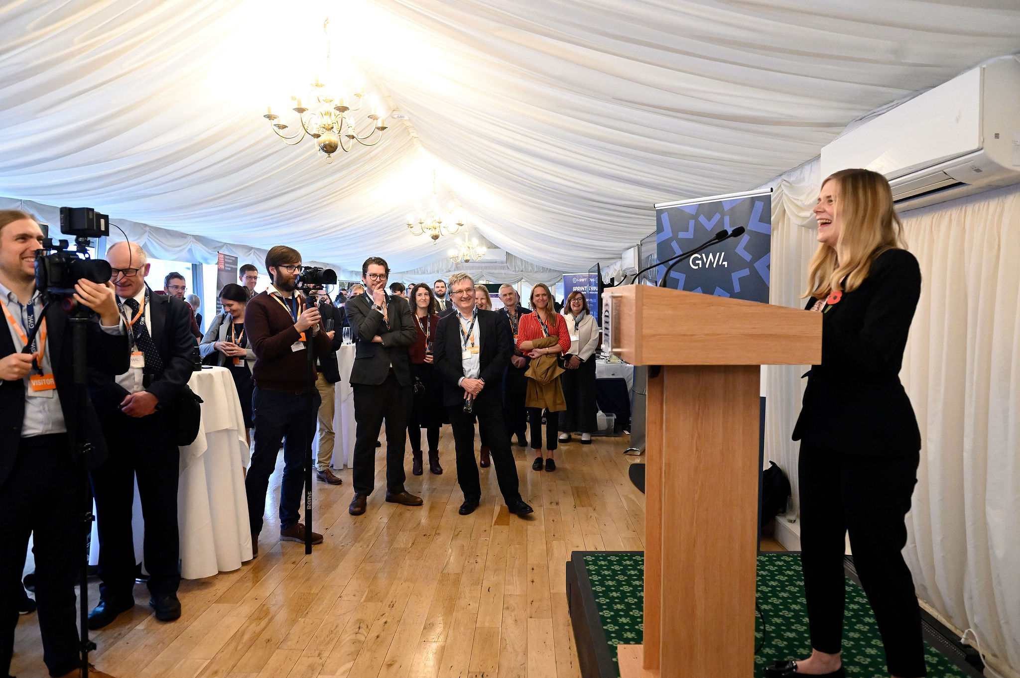 The image shows Claire Hazelgrove (MP for Filton & Bradley Stoke) delivering her opening address to attendees at the GW4 Innovation Showcase in October 2025.