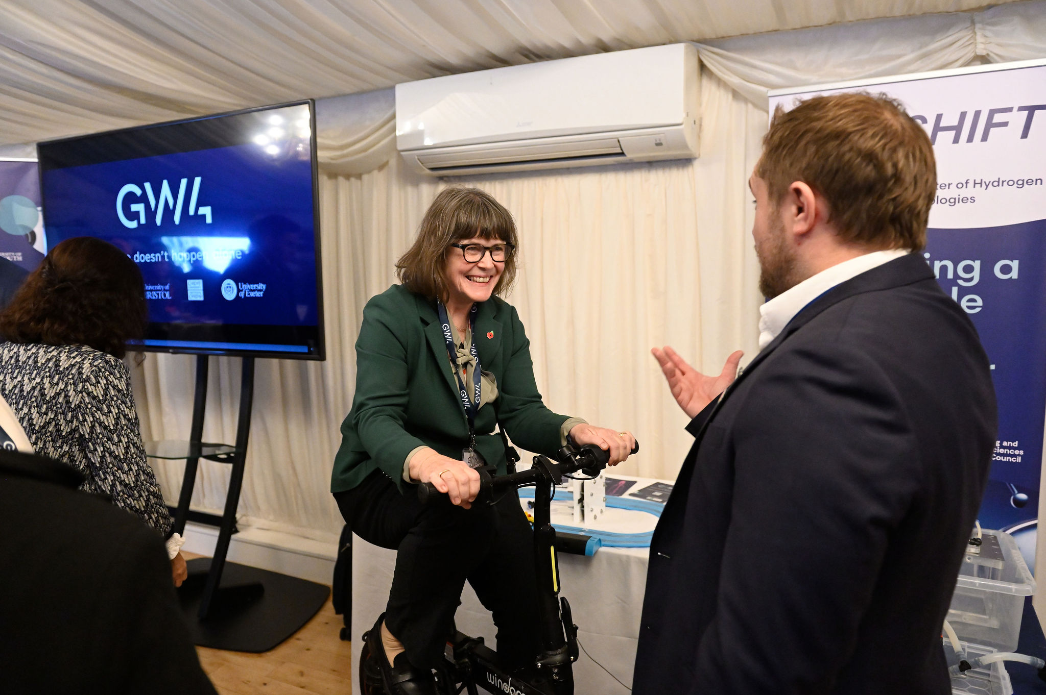 The image shows Baroness Morgan of Drefelin on the GW-SHIFT Hydrogen Bike, supervised by Dr James Courtney