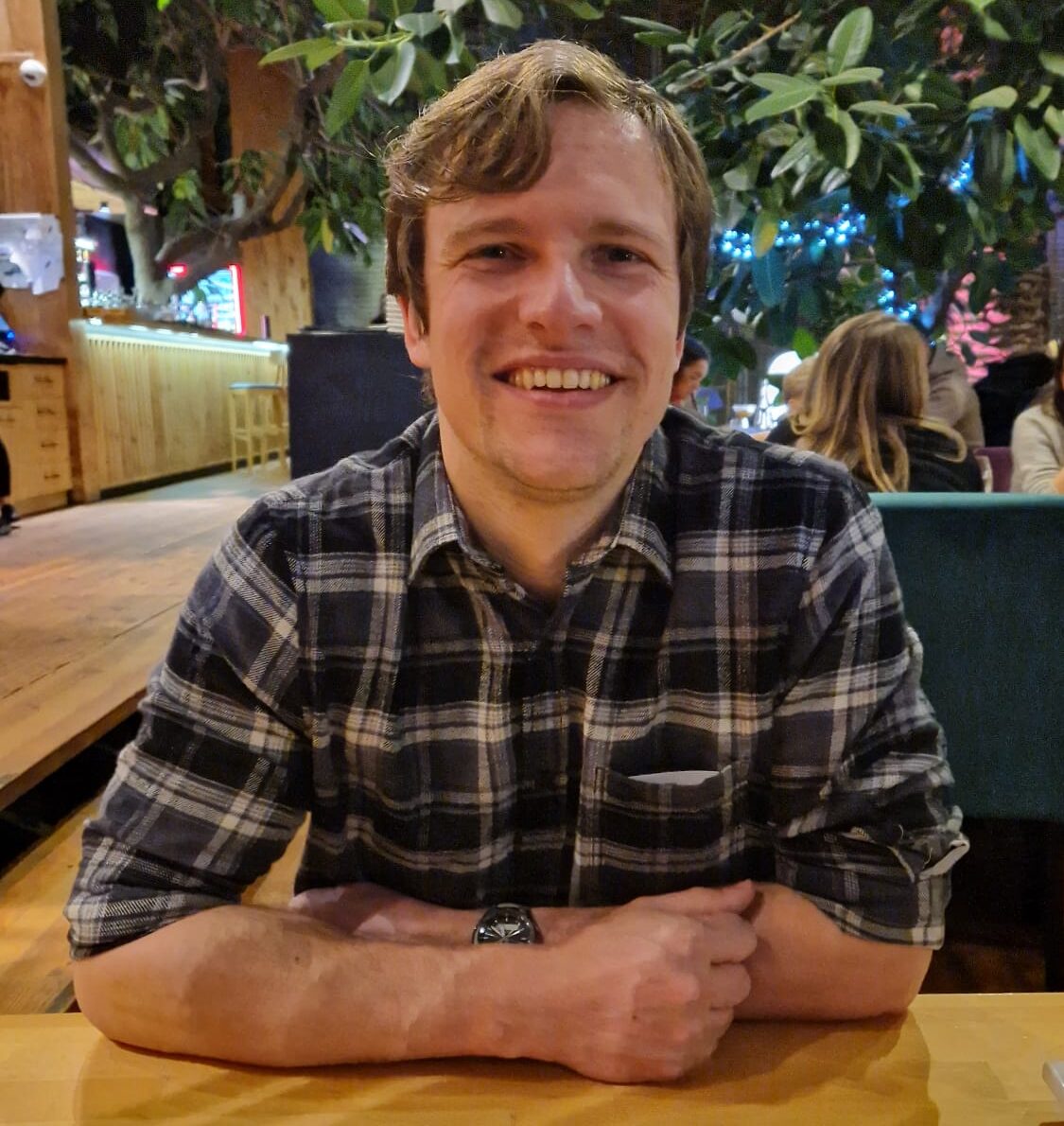 Profile picture of Matthew Stevens smiling with arms folded on table in front of them.