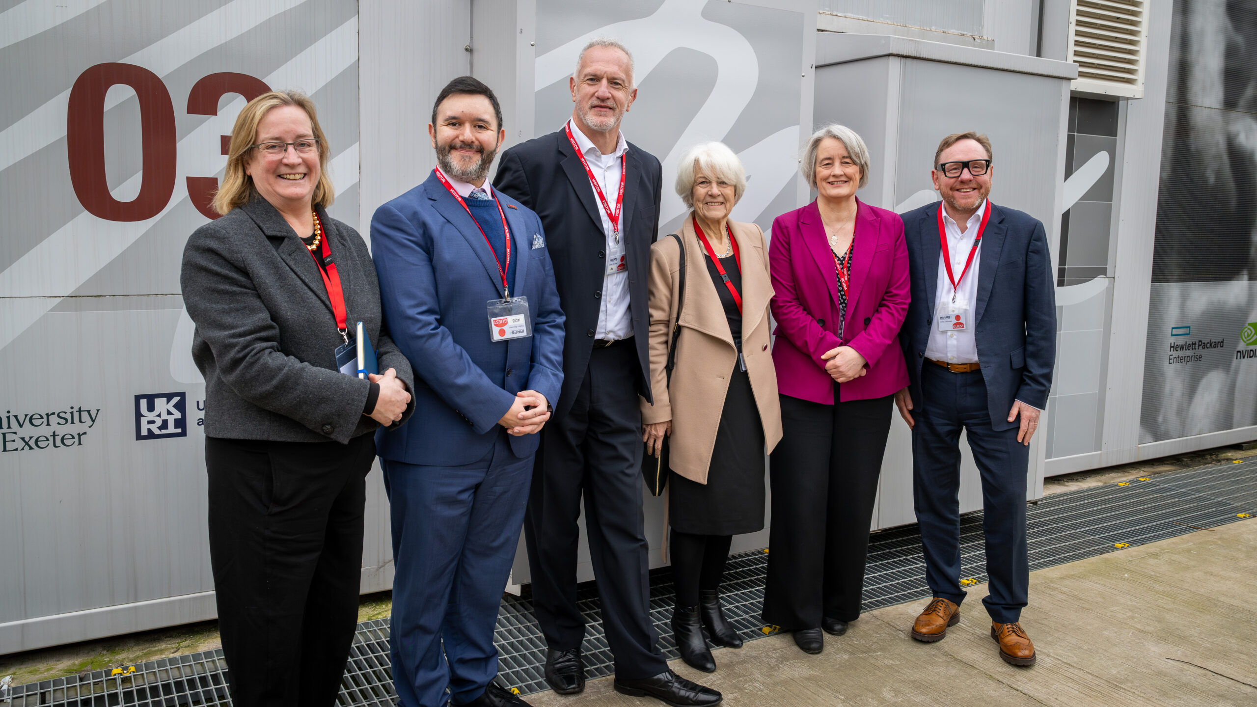 Group of regional MPs and leaders with VC of Bath and Bristol Universities standing outside in front of GW4 Isambard 3 supercomputer.