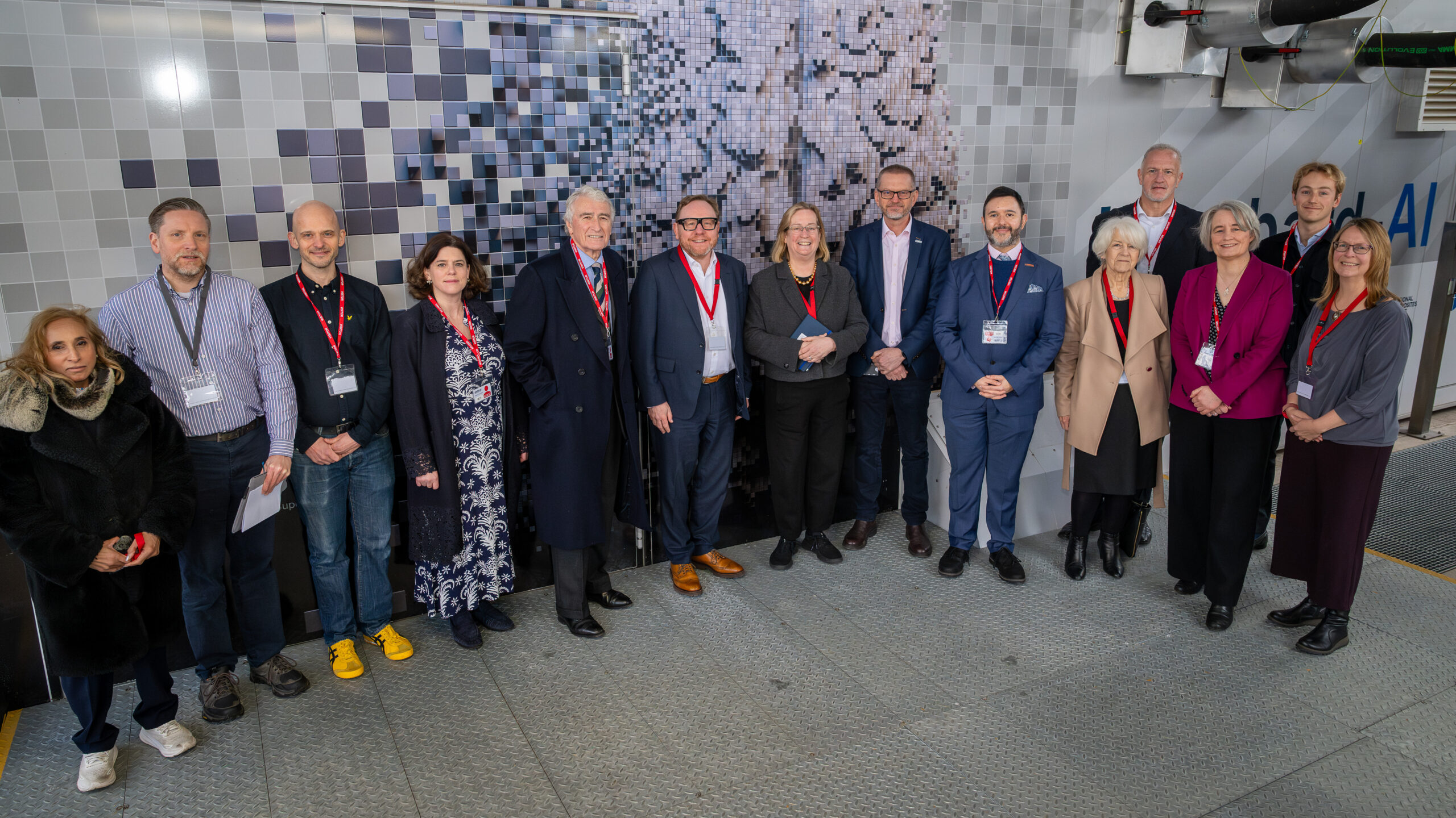Group of policymakers, business leaders and GW4, Bath and Bristol University representatives standing by Isambard-AI supercomputer.