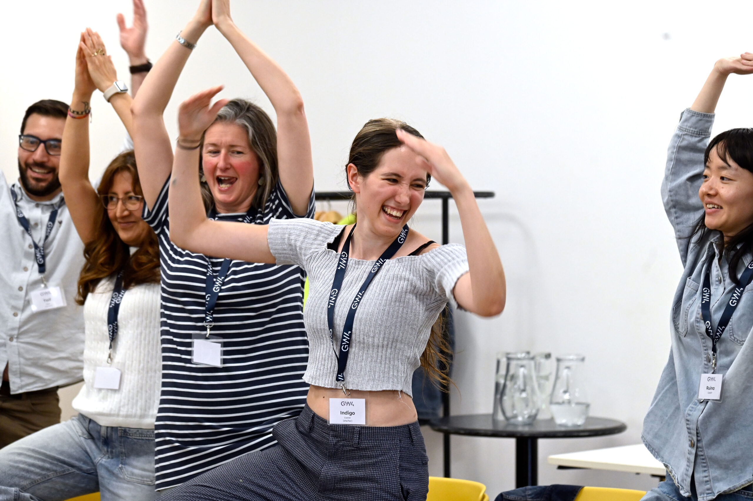 A group of participants stretching their arms and lifting one leg.